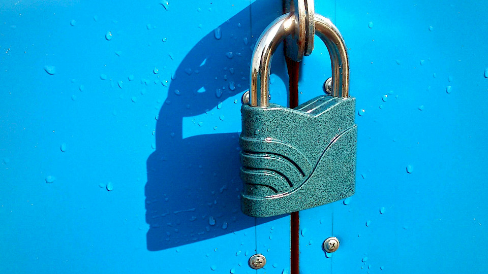 A closed padlock on a blue lock